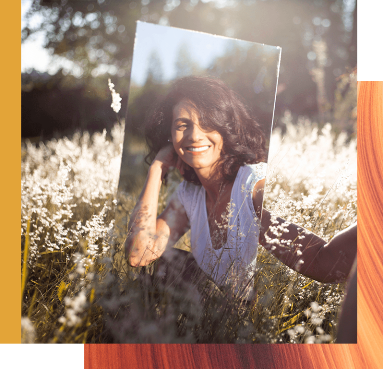 A woman looks happily at herself in a mirror